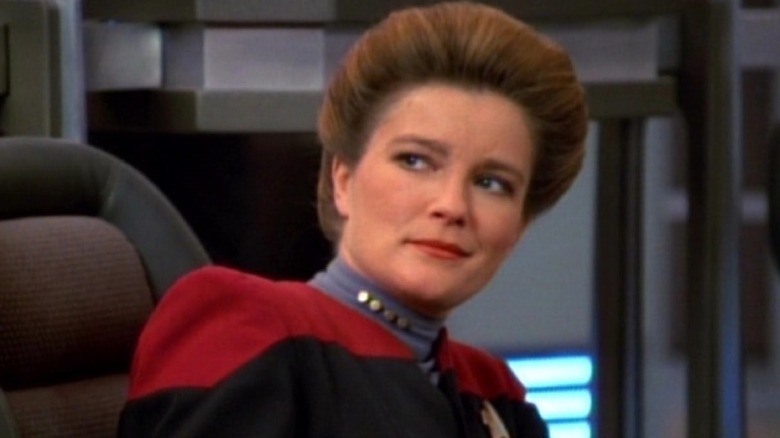 Captain Janeway grinning in the captain's chair in Star Trek Voyager