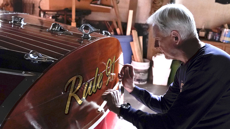 Gibbs painting his boat