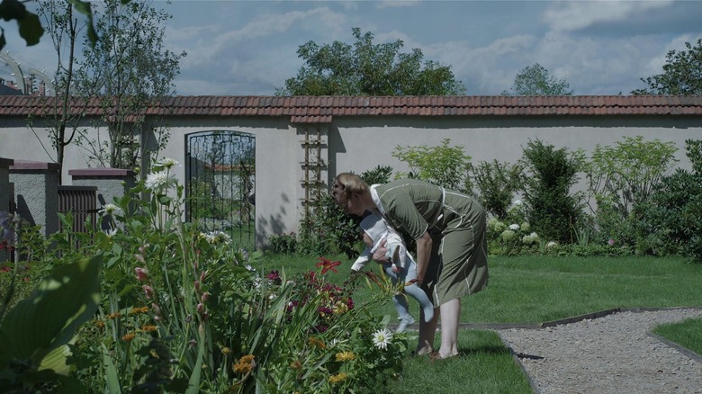 A mother and infant in a garden in The Zone of Interest (2023)