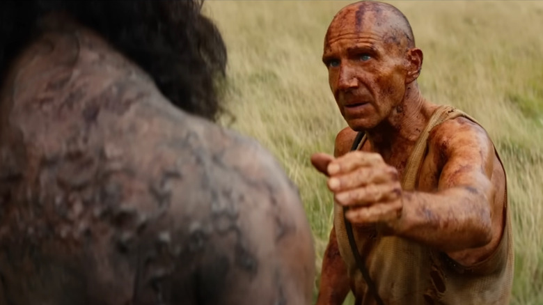 Dr. Kelson, covered in orange iodine, holds out a hand towards a scarred infected in "28 Years Later: The Bone Temple"