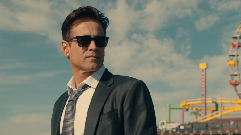 John Sugar wearing sunglasses near an amusement pier in "Sugar" (2024-present)