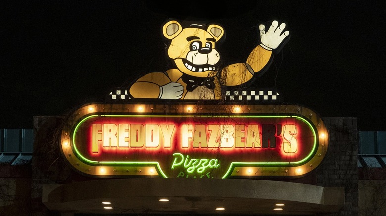 The Freddy Fazbear's Pizza sign lit up in the dark in 
