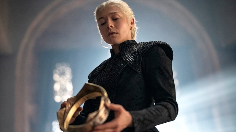 Rhaenyra Targaryen looking down at a crown she's holding in Season 3 of 
