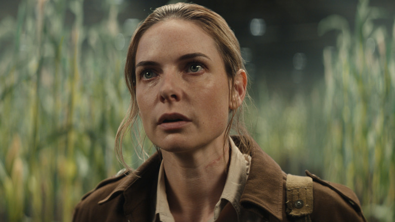 Juliette frowning and standing in a crop field in "Silo."