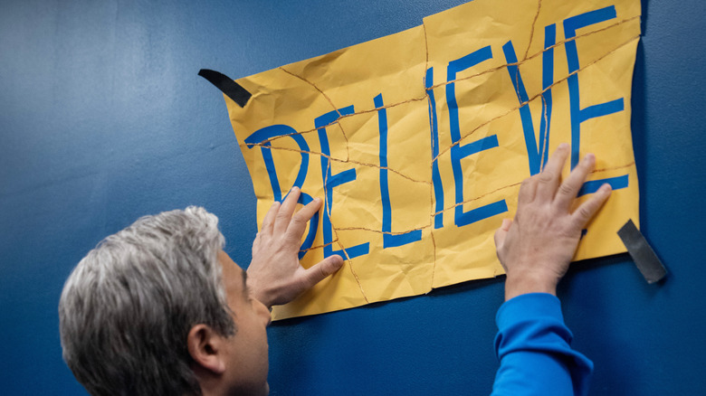 Nate putting up a torn but repaired "believe" sign at the end of Ted Lasso season 3 (2023)
