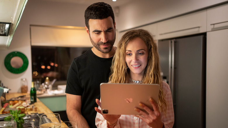 Roy Kent and Keeley Jones looking at an iPad together in Ted Lasso season 2 (2023)