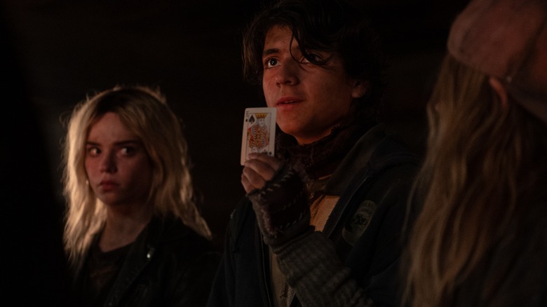 Travis holding up a card next to Nat on Yellowjackets