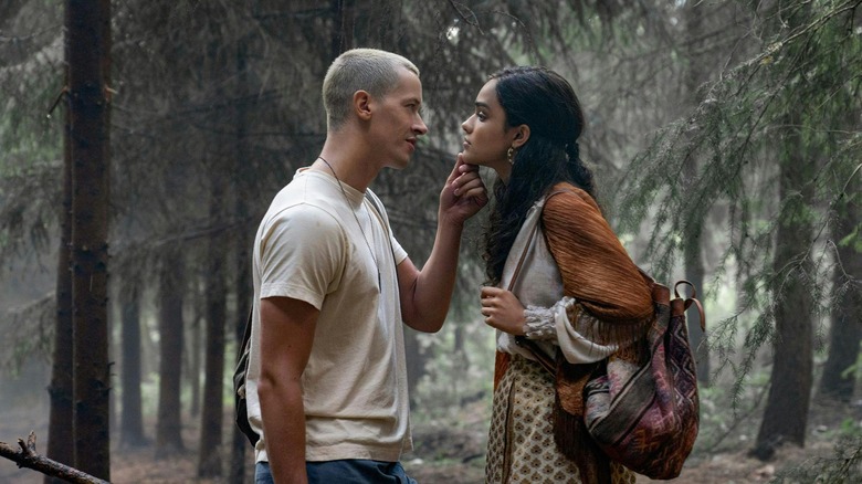 Coriolanus and Lucy standing in the woods about to kiss in The Hunger Games: The Ballad of Songbirds and Snakes