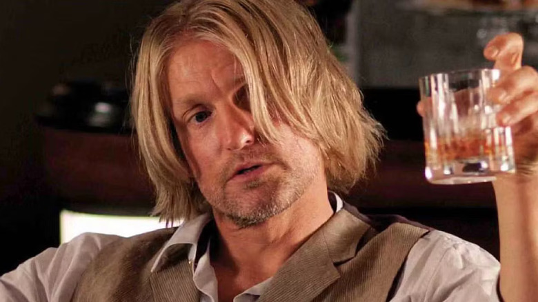 Haymitch holding a drink on the train in The Hunger Games