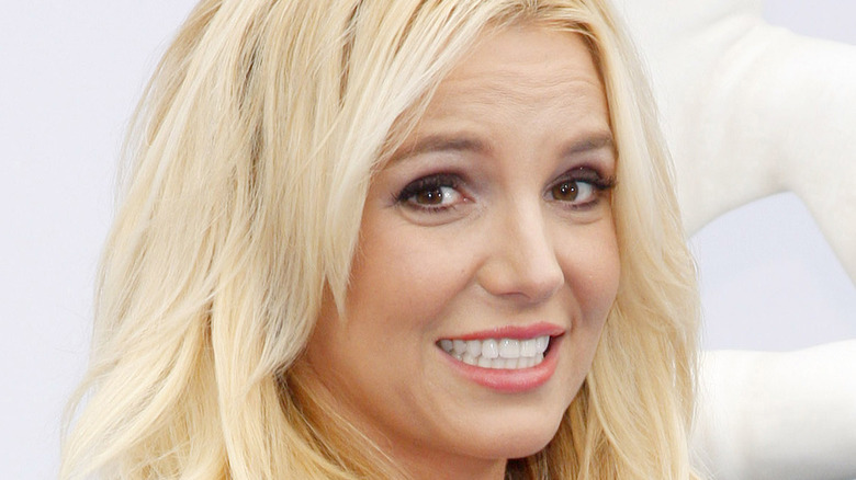 Britney Spears smiling and grimacing slightly 