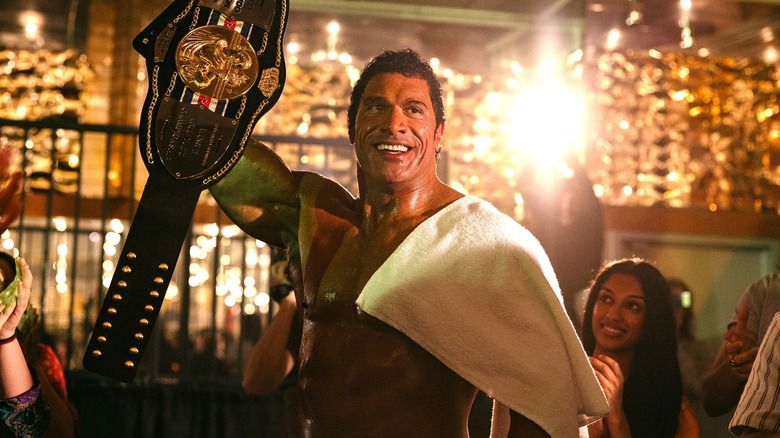 Dwayne Johnson's Mark Kerr holding up the title in The Smashing Machine
