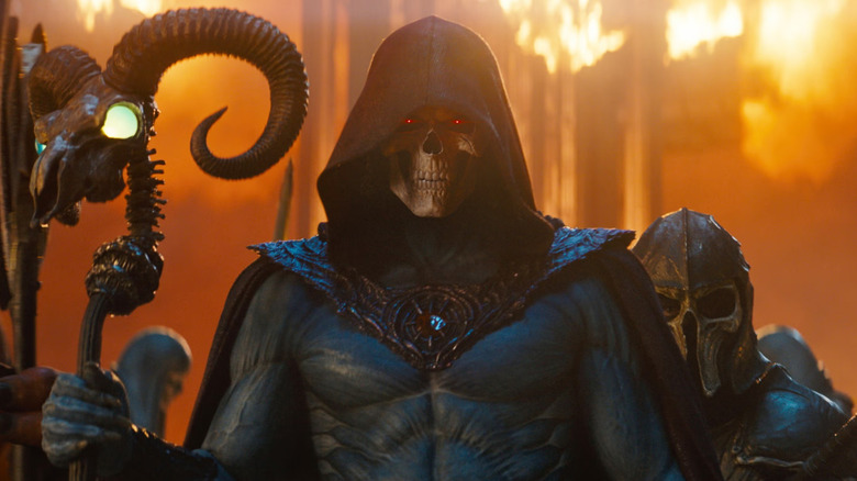 Skeletor holding his ram staff surrounded by flames and soldiers in 