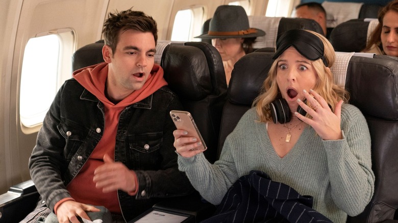 Brooke and Cary on plane shocked looking at phone