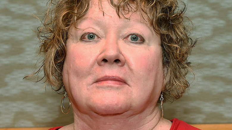 S.E. Hinton posing with her book