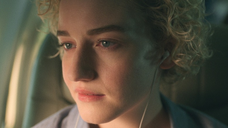 Ruth Langmore wearing headphones on a plane