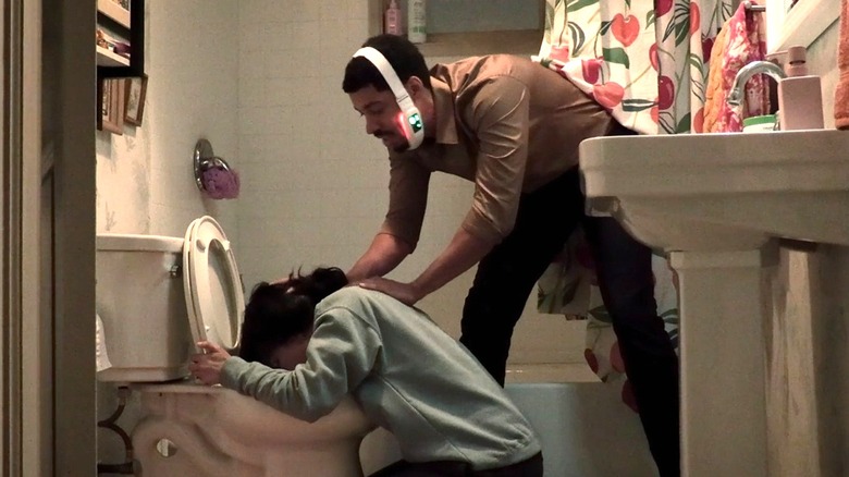 Detrick holding Nicole's hair back while she's throwing up in her bathroom