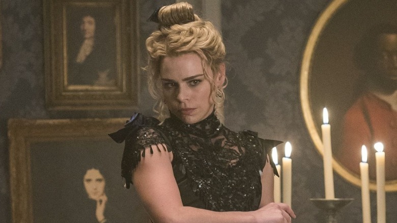 Brona (as Lily) in Dorian's house holding candlestick