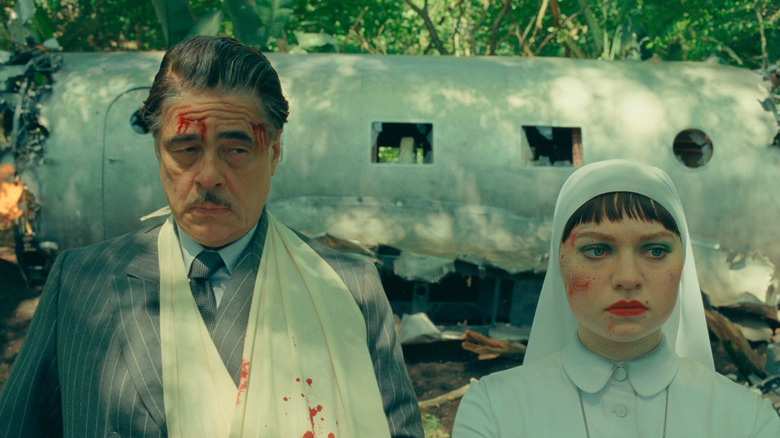 Zsa-Zsa and Liesl stand bloodied by plane wreckage in the forest in 