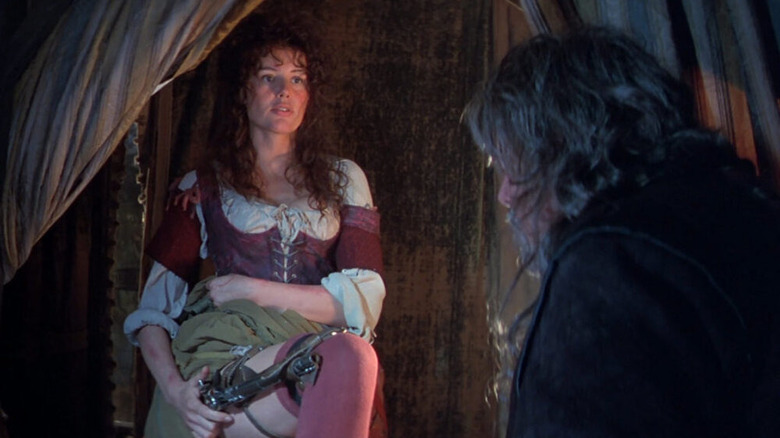 Geena Davis staring at man with weapon strapped to her thigh