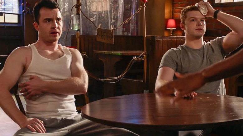 Mickey and Ian sitting at a table icing their wounds