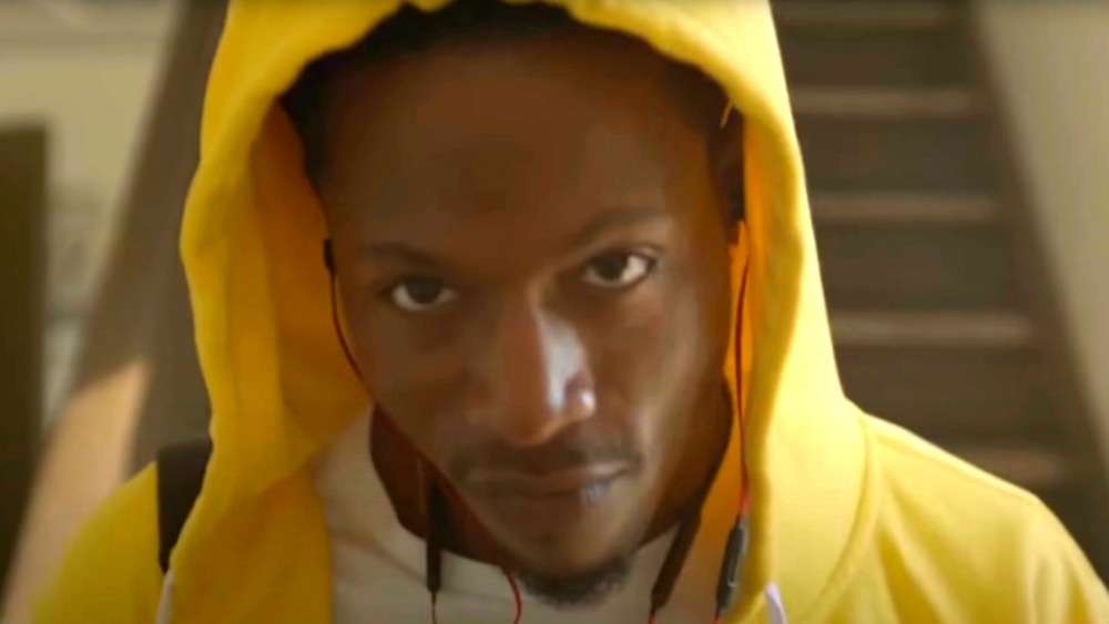 Joey Bada$$ in a hoodie looking at camera