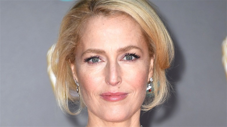 Gillian Anderson wearing diamond earrings smiling