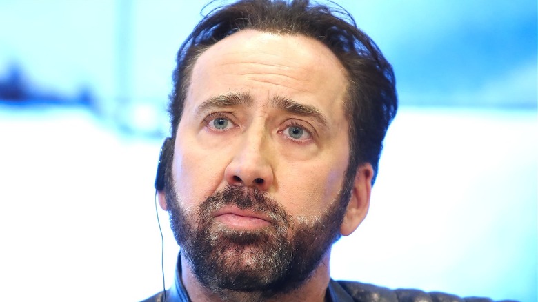 Nicolas Cage listening to earpiece