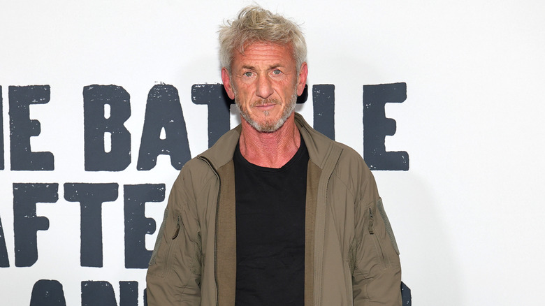 Sean Penn in a brown jacket and black shirt