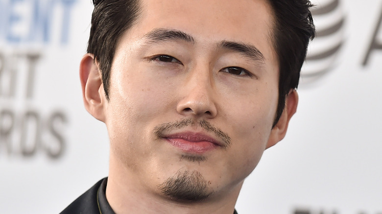 Steven Yeun smirking