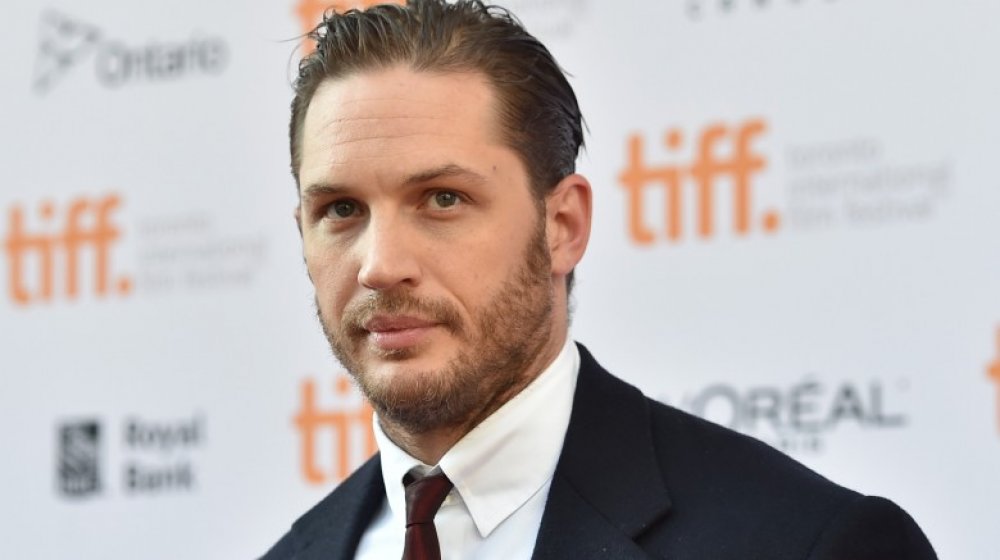 Tom Hardy appears on a carpet at the Toronto International Film Festival