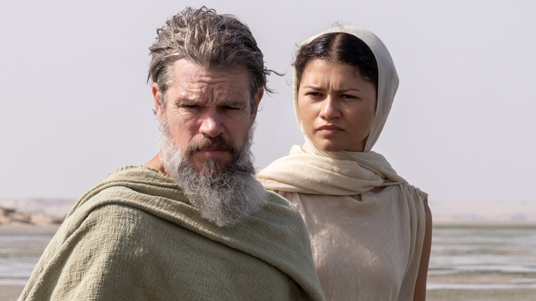 Odysseus stand with Athena on a beach in 