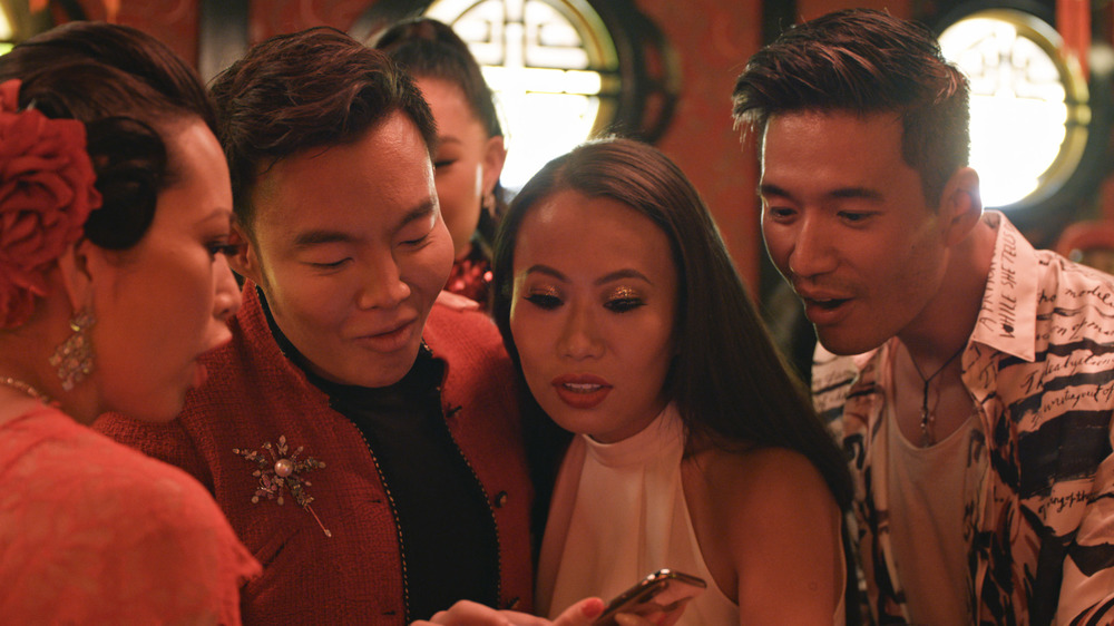 Bling Empire cast looking at mobile phone