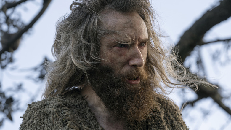A disheveled Gandalf stands with trees behind him in "The Rings of Power" (2022-present)
