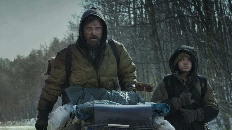 Man and Boy walk along a deserted highway in "The Road" (2009)