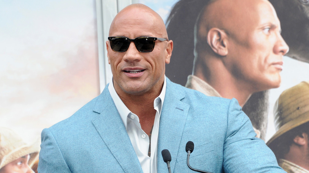 The Rock in sunglasses at podium