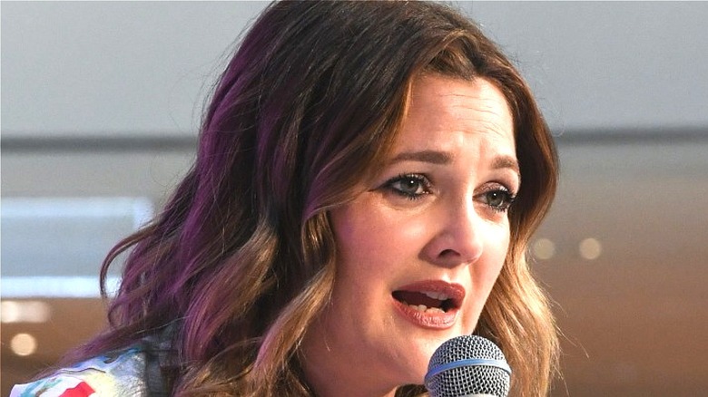Drew Barrymore speaking into microphone