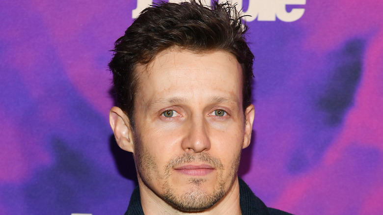 Will Estes in front of a purple background