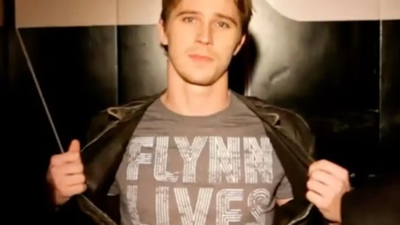 Sam opens jacket to reveal "Flynn Lives" shirt in "Tron: The Next Day" (2011)