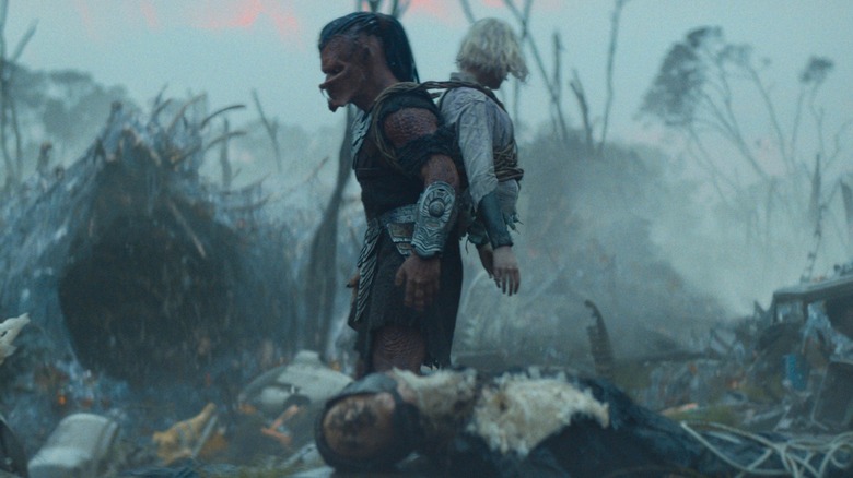 Dek carrying Thia on his back in Predator: Badlands