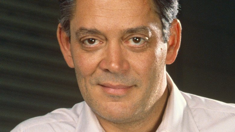 Raul Julia posing against a gray backdrop