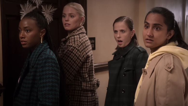 The girls standing in front of the dorm room looking shocked