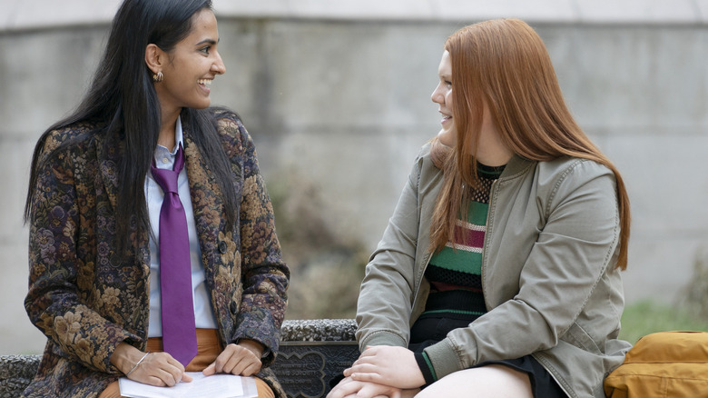 Bela and Jorja sitting on a bench and talking