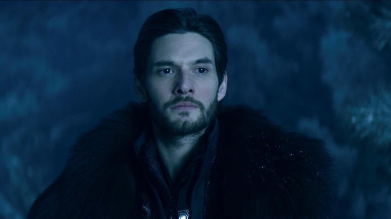 The Darkling wearing a black fur coat and looking serious 