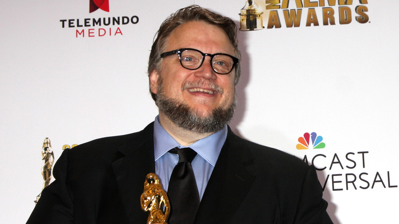 Del Toro posing at premiere with Academy Award