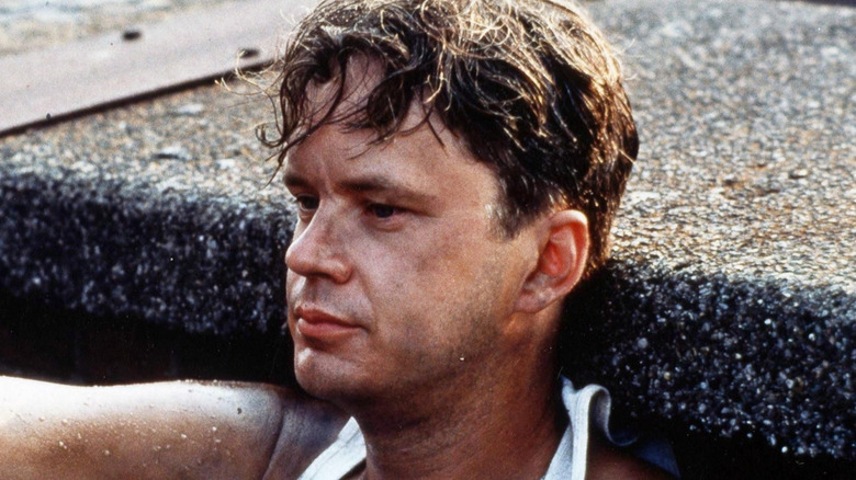 Andy Dufresne sits against a wall on the roof in 