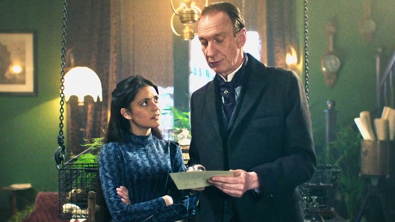 Sherlock Holmes examining a letter in front of Amelia in "Sherlock & Daughter"