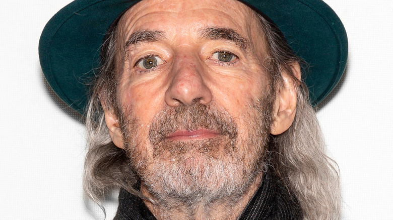 Harry Shearer wearing a green hat