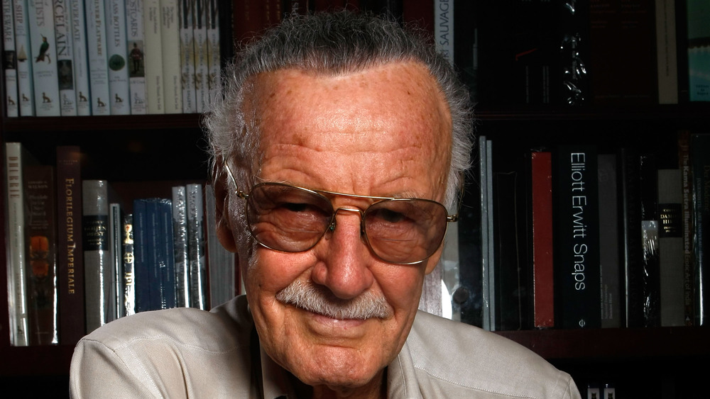 Stan Lee in front of a bookshelf