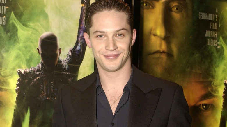 Tom Hardy standing in front of posters for Star Trek: Nemesis