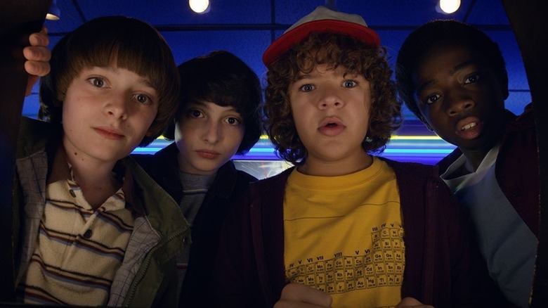 The Stranger Things boys playing an arcade game